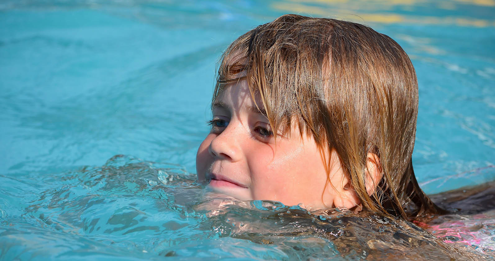 Flicka som simmar i pool