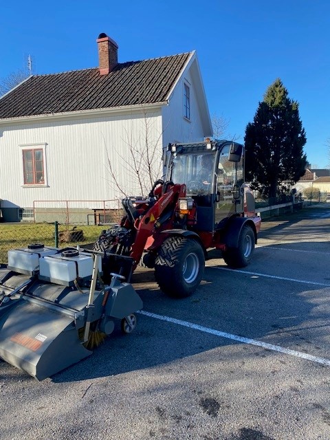 Sopmaskin kopplad på röd traktor